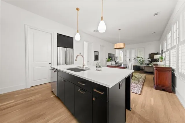 a large kitchen with stainless steel appliances a sink dishwasher and a fireplace with wooden floor