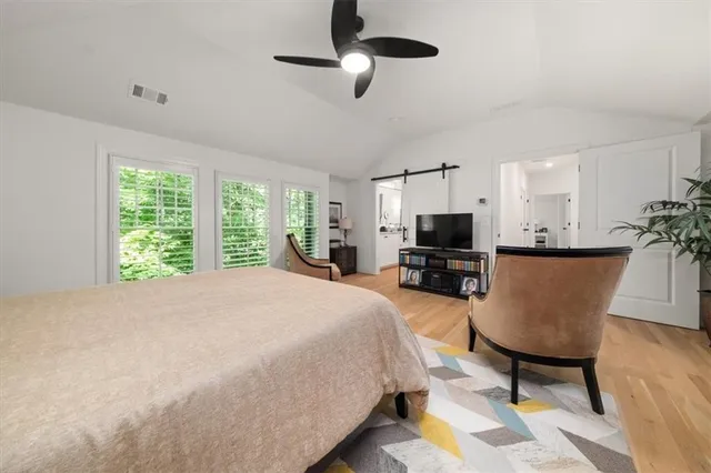 a bedroom with a bed a flat screen tv and a couch