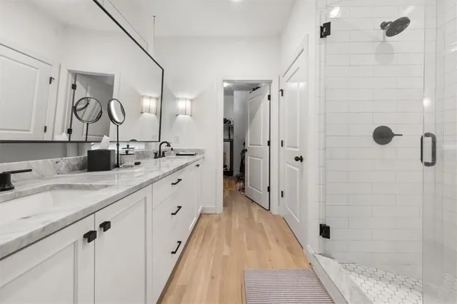 a spacious bathroom with a double vanity sink mirror and shower