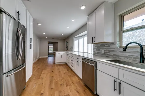 a large kitchen with stainless steel appliances sink a microwave and cabinets