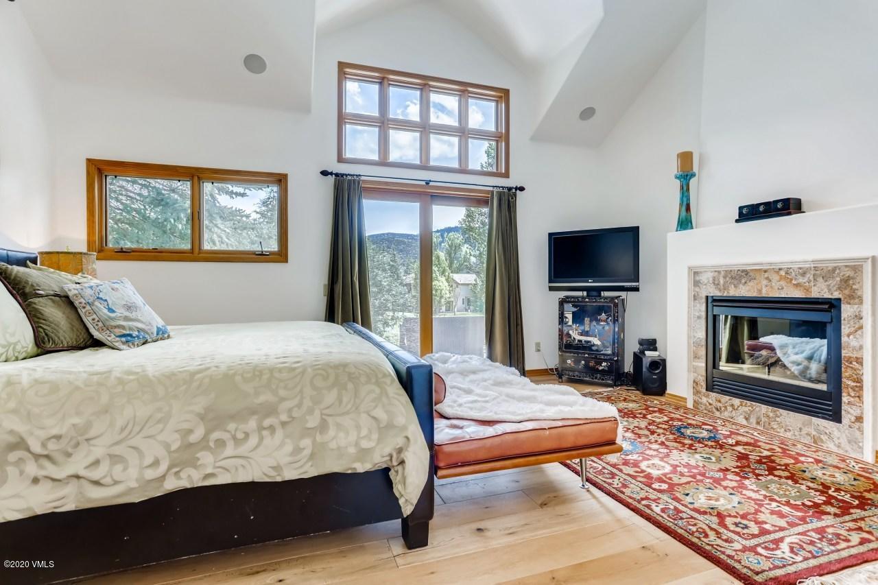 145 Hereford Road Edwards, CO 81632 - Photo 14 of 24 a bedroom with a bed a fireplace and a flat screen television