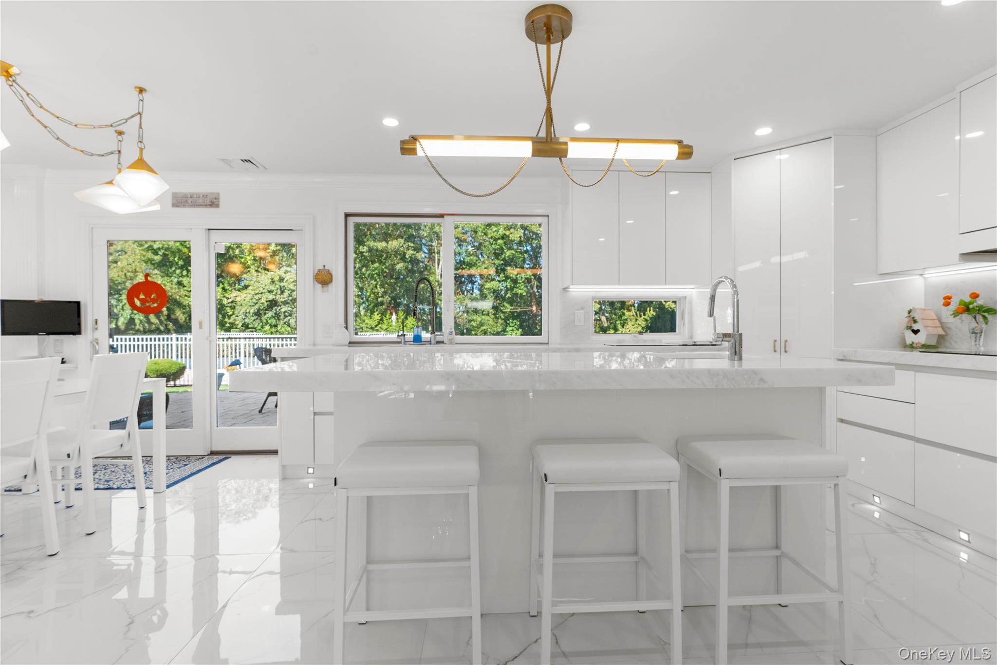 28 Annandale Road Commack, NY 11725 - Photo 5 of 29 Kitchen featuring modern cabinets, a kitchen bar, white cabinetry, light stone counters, and recessed lighting