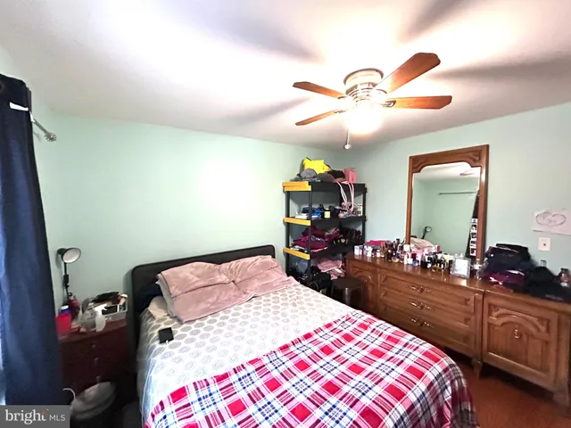 a bedroom with a bed and dresser with mirror