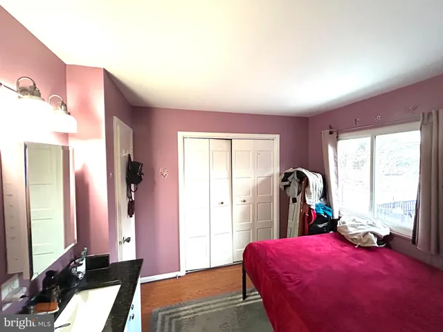 a bedroom with a large bed and large windows