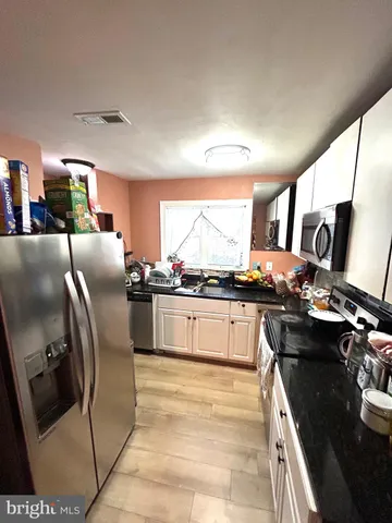 a kitchen with stainless steel appliances granite countertop a sink a stove and a refrigerator