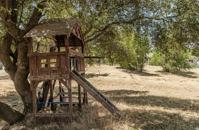 a view of a house with large trees