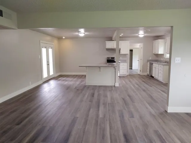 a view of a kitchen with cabinets and wooden floor
