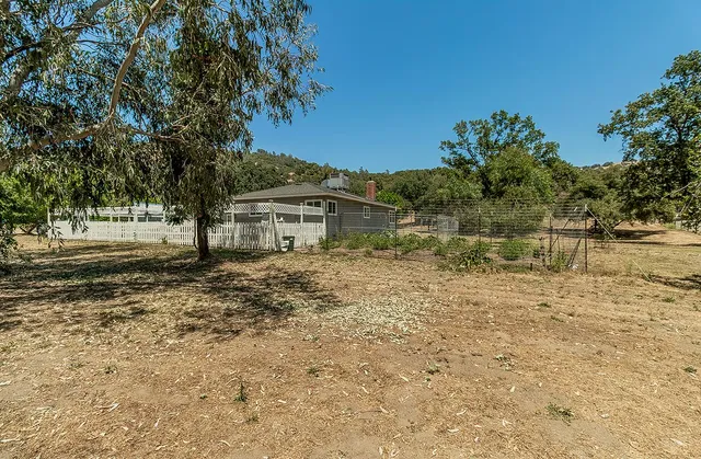 a view of a yard with wooden fence