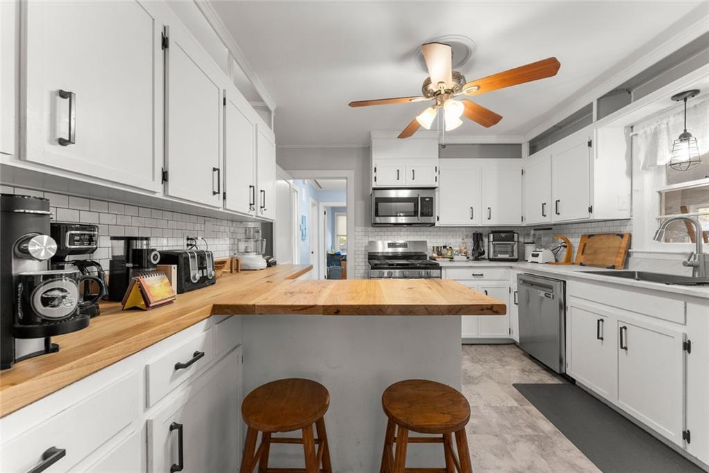 3089 Highway 17 Alternate Toccoa, GA 30577 - Photo 14 of 51 a kitchen with stainless steel appliances a sink a stove a refrigerator cabinets and a window