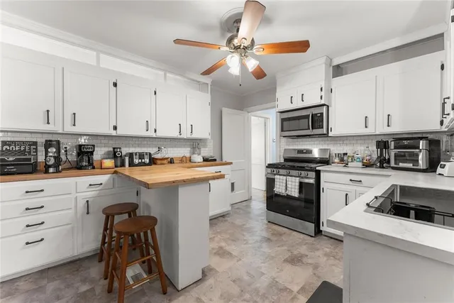 a kitchen with granite countertop a sink a counter top space appliances and cabinets
