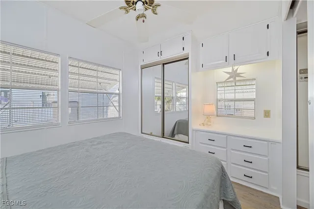 a spacious bedroom with a bed a dresser and a chandelier