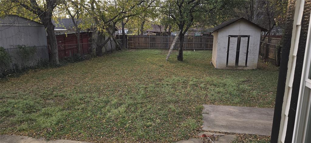 405 Southwest 6th Street Grand Prairie, TX 75051 - Photo 11 of 16 Fenced backyard with a storage unit
