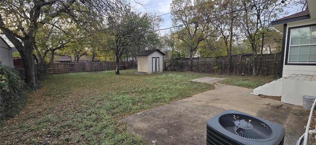 405 Southwest 6th Street Grand Prairie, TX 75051 - Photo 12 of 16 Fenced backyard with a shed and a patio