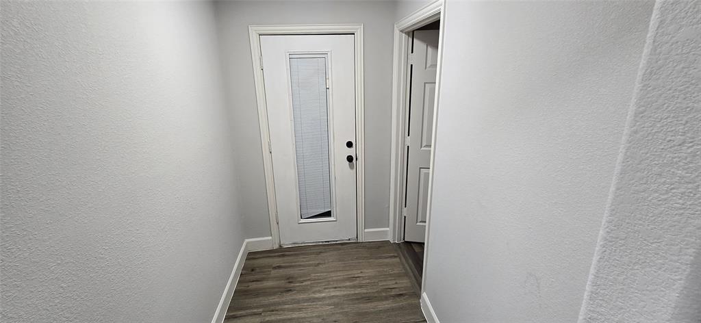 405 Southwest 6th Street Grand Prairie, TX 75051 - Photo 15 of 16 Hall with a textured wall and dark wood-style flooring