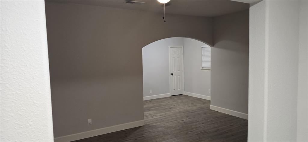 405 Southwest 6th Street Grand Prairie, TX 75051 - Photo 4 of 16 Spare room with arched walkways and dark wood-style floors