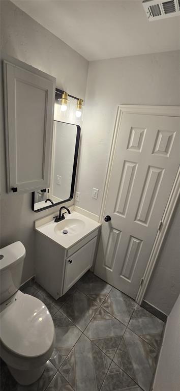 405 Southwest 6th Street Grand Prairie, TX 75051 - Photo 9 of 16 Half bath with vanity and dark tile patterned floors