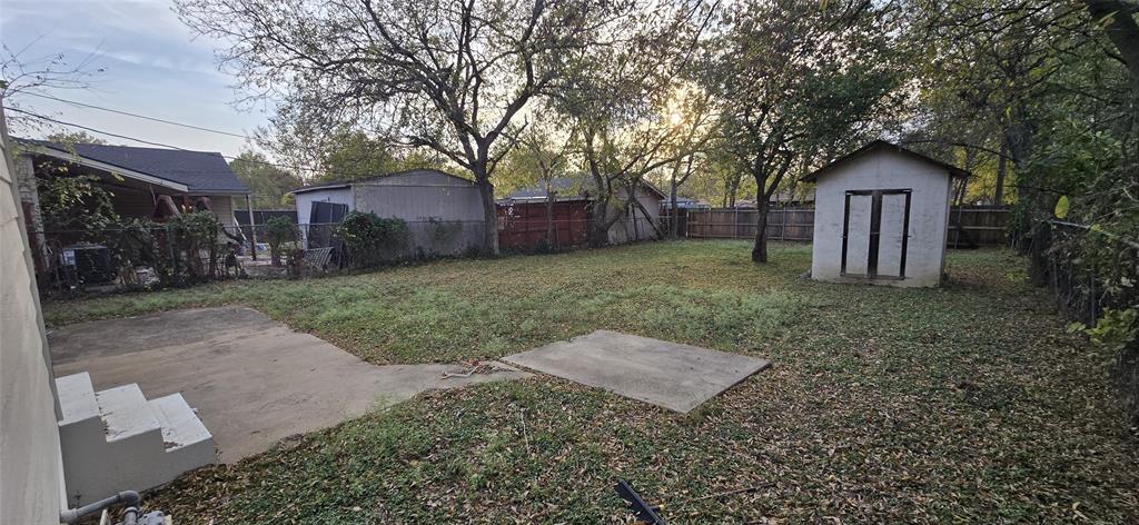 405 Southwest 6th Street Grand Prairie, TX 75051 - Photo 10 of 16 Fenced backyard featuring a storage unit