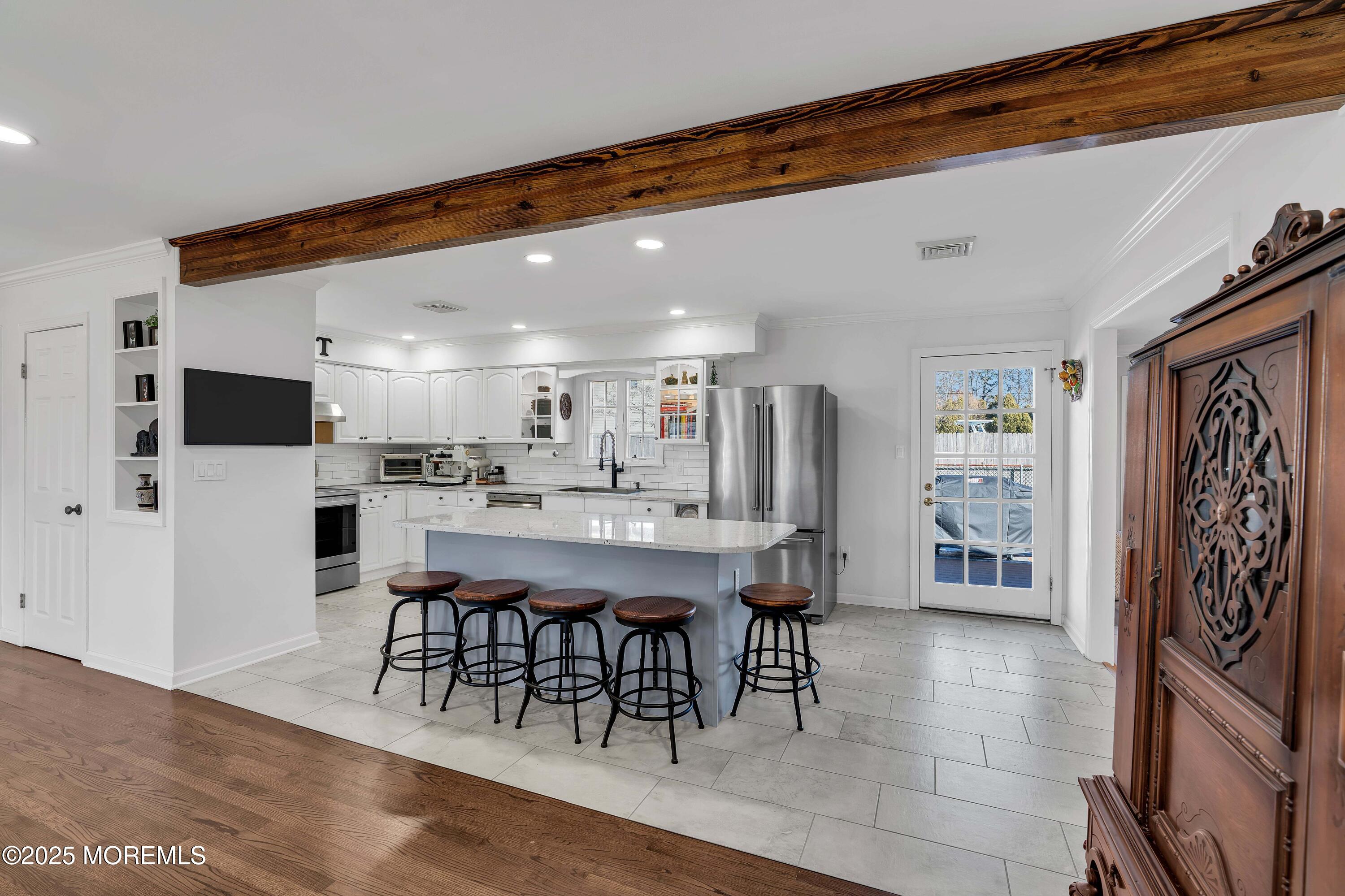 520 Windsor Street Forked River, NJ 08731 - Photo 12 of 36 a dining area with stainless steel appliances kitchen island granite countertop a table chairs and a refrigerator