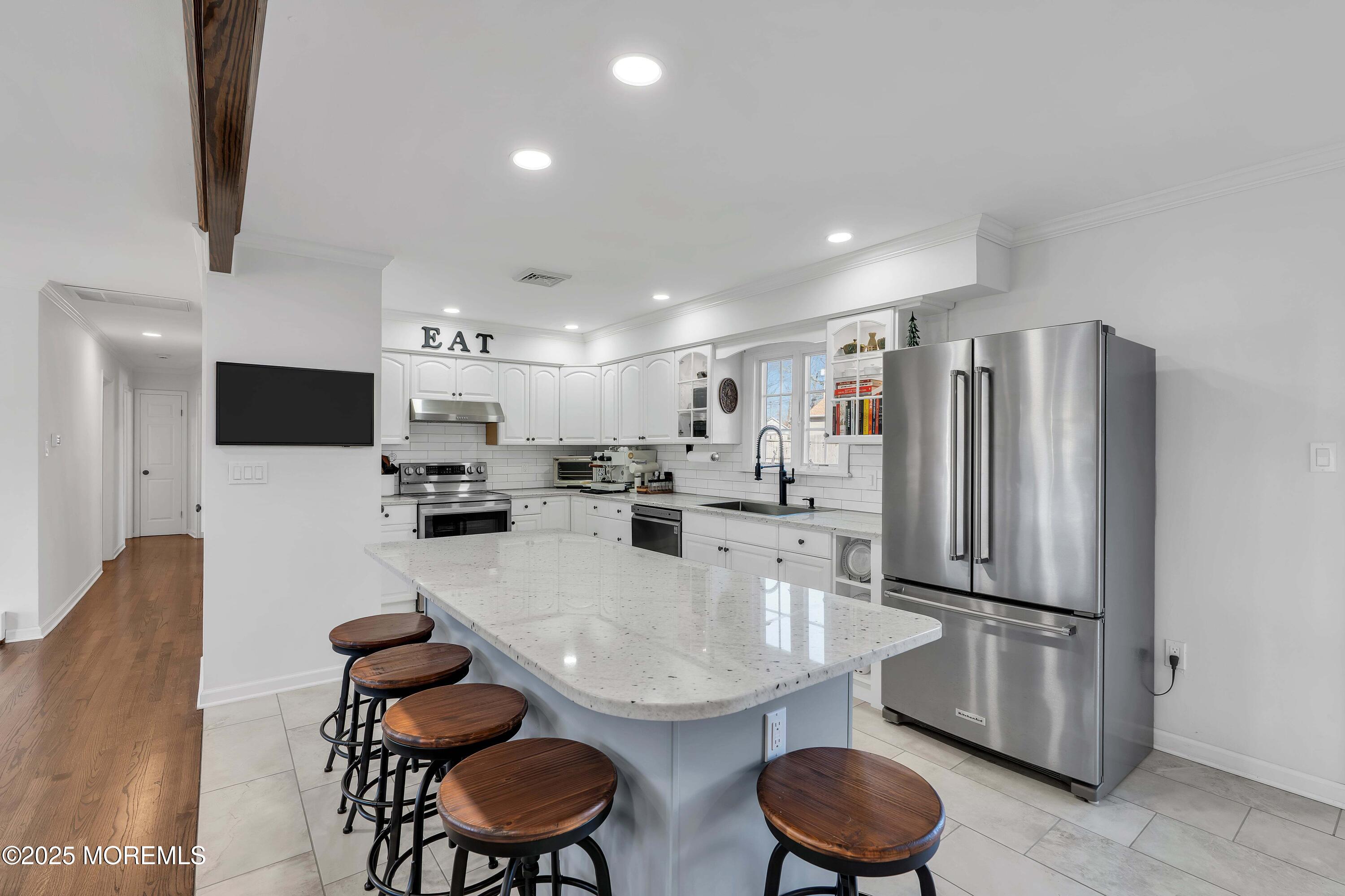 520 Windsor Street Forked River, NJ 08731 - Photo 13 of 36 a kitchen with stainless steel appliances granite countertop a dining table chairs refrigerator and microwave