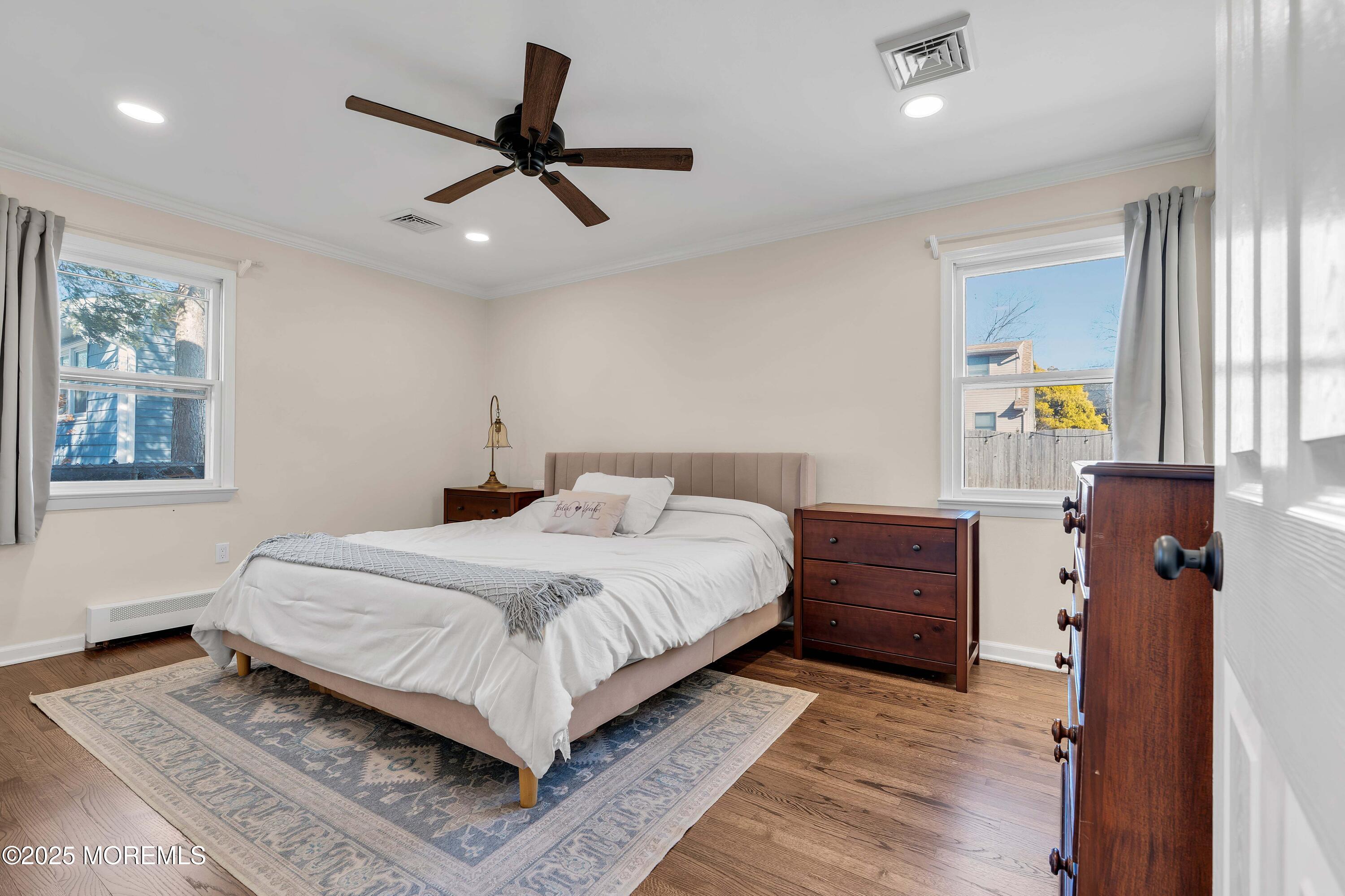 520 Windsor Street Forked River, NJ 08731 - Photo 25 of 36 a bedroom with a large bed and a chandelier