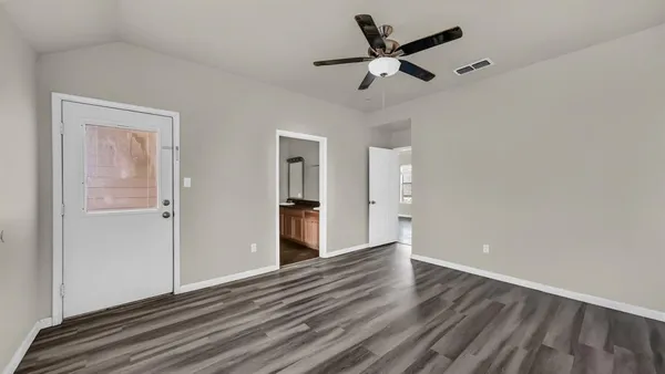 a view of empty room with wooden floor