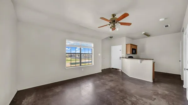 a view of a livingroom with a ceiling fan and window
