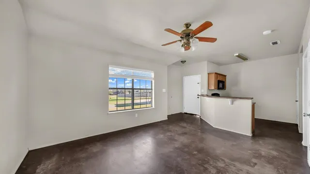 a view of a livingroom with a ceiling fan and window