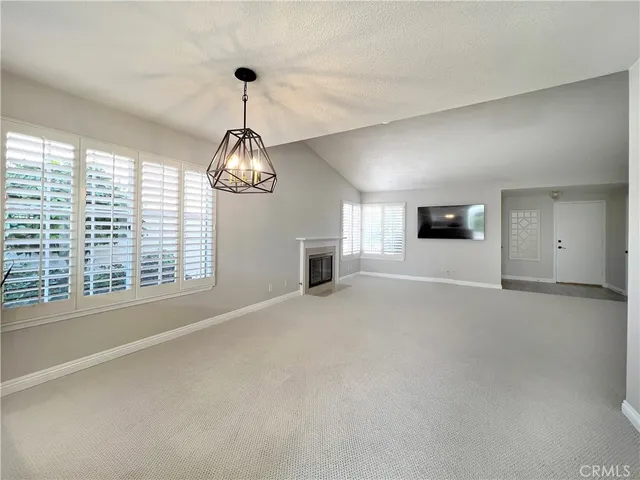 a view of an empty room with a window and fireplace