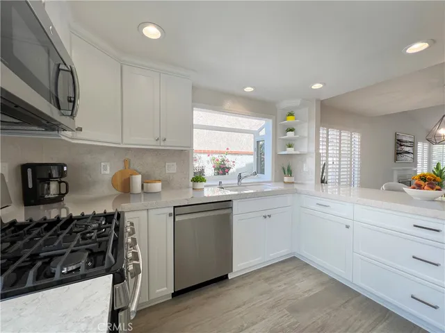 a kitchen with white cabinets and appliances