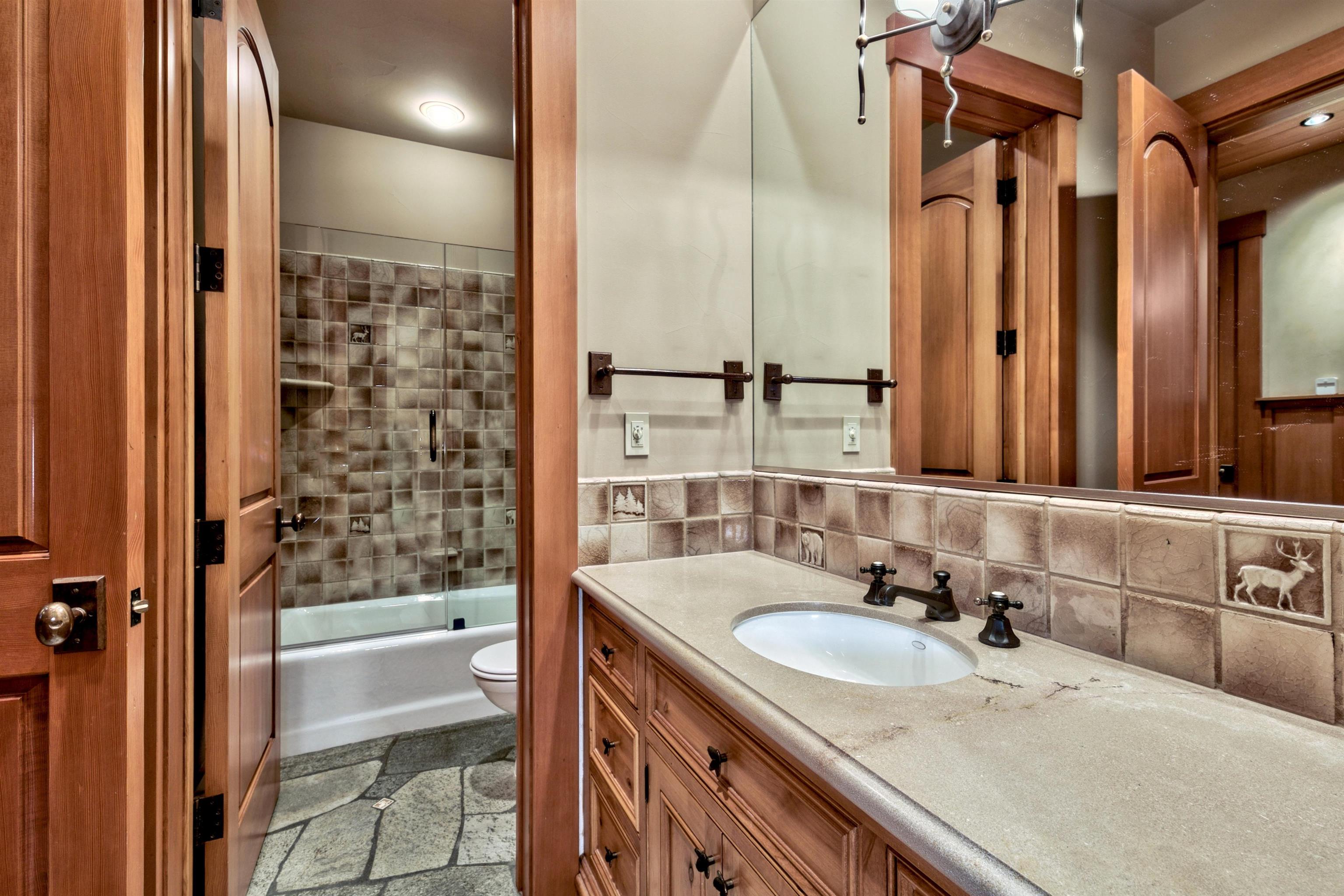 244 Hidden Lake Loop Olympic Valley, CA 96146 - Photo 15 of 20 a bathroom with a granite countertop sink and a mirror