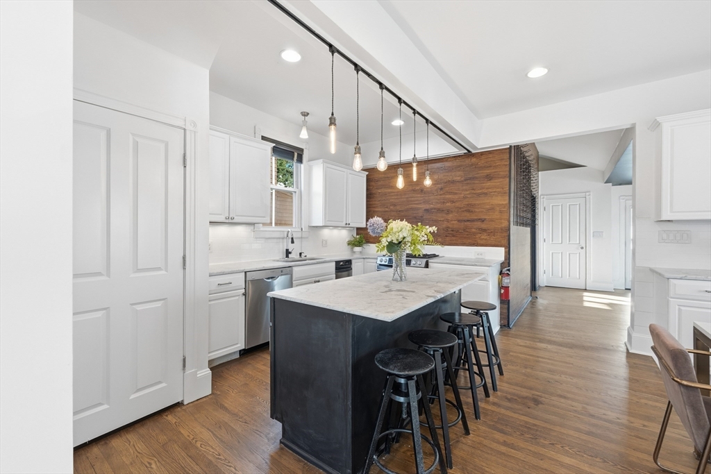 22 Spring Street Everett, MA 02149 - Photo 12 of 40 a kitchen with stainless steel appliances kitchen island a hardwood floor and chairs