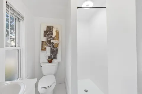 a white toilet sitting next to a bathroom sink