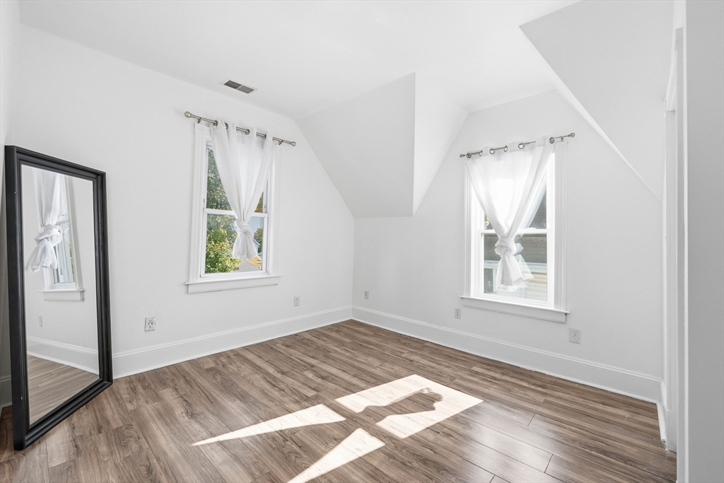 22 Spring Street Everett, MA 02149 - Photo 21 of 40 an empty room with wooden floor and windows