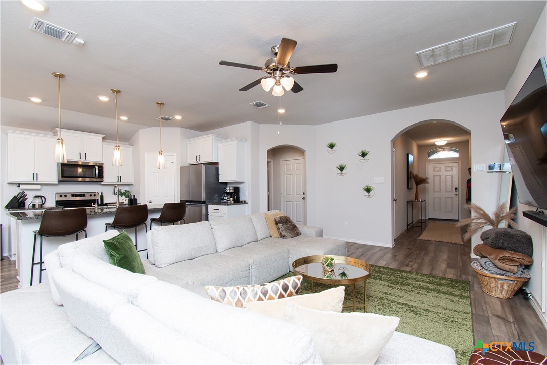 8415 Cantera Rdg Road Temple, TX 76502 - Photo 3 of 24 a living room with furniture a fireplace and kitchen view