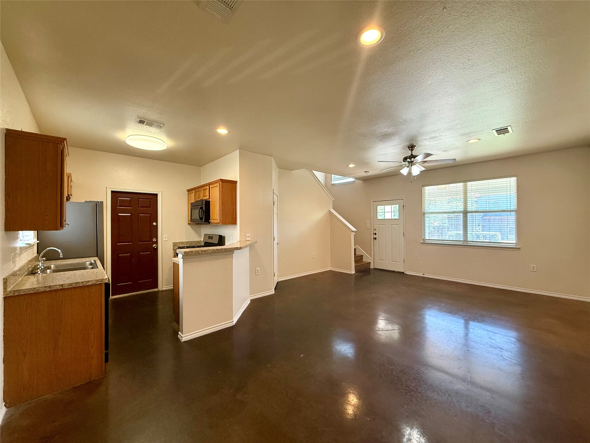 6912 Meador Avenue, Unit A Austin, TX 78752 - Photo 7 of 24 a view of a kitchen with kitchen island wooden floor center island stainless steel appliances and windows