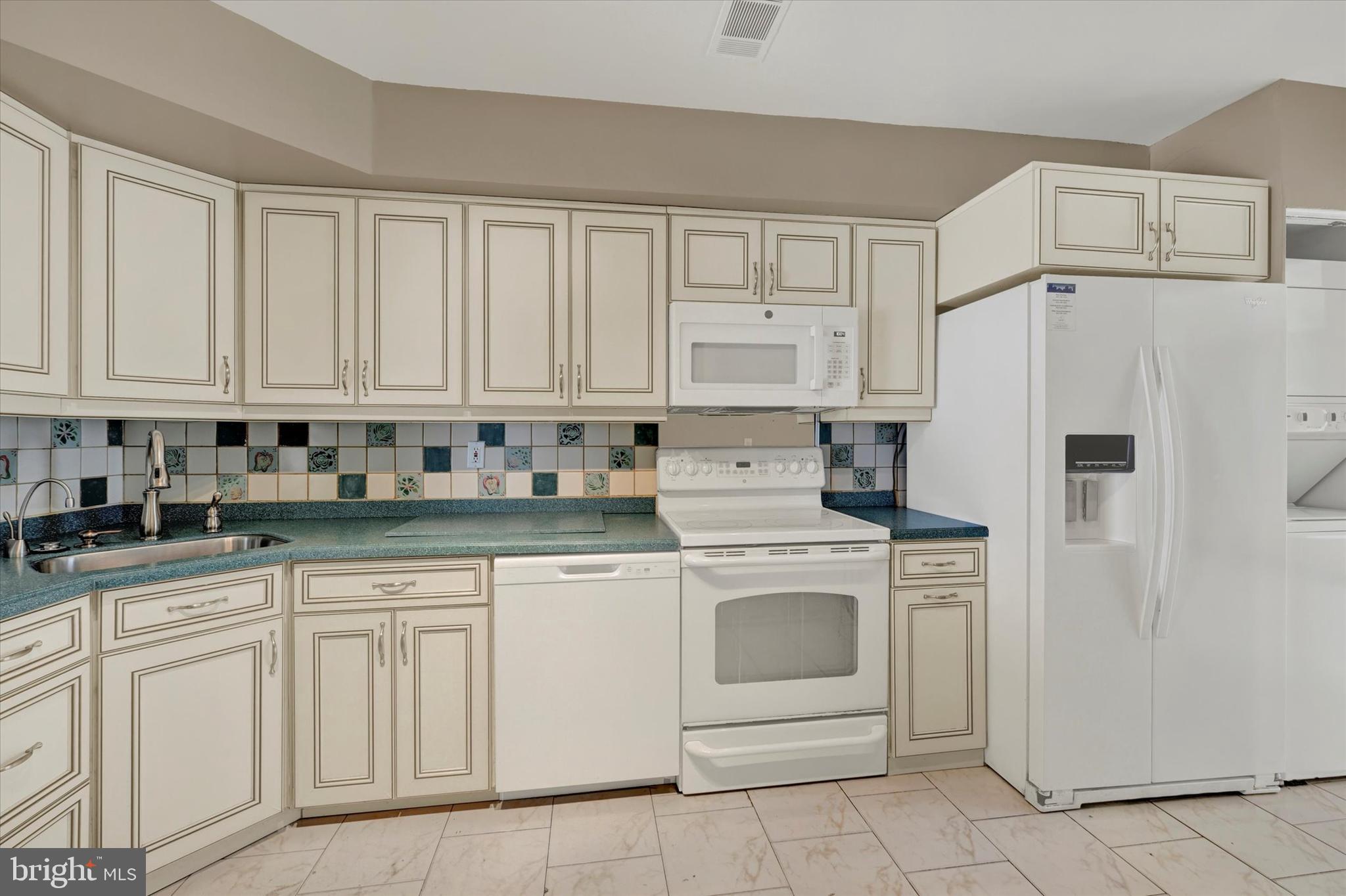 25 Tanner Court, Unit H Baltimore, MD 21208 - Photo 12 of 29 a kitchen with white cabinets and white appliances