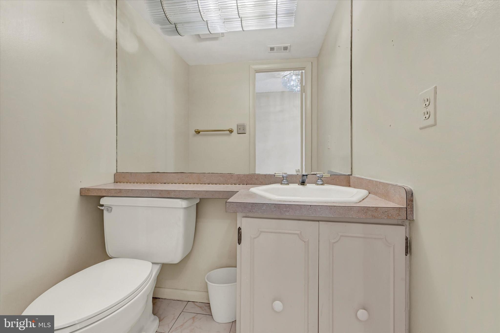 25 Tanner Court, Unit H Baltimore, MD 21208 - Photo 14 of 29 a bathroom with a granite countertop toilet sink and mirror