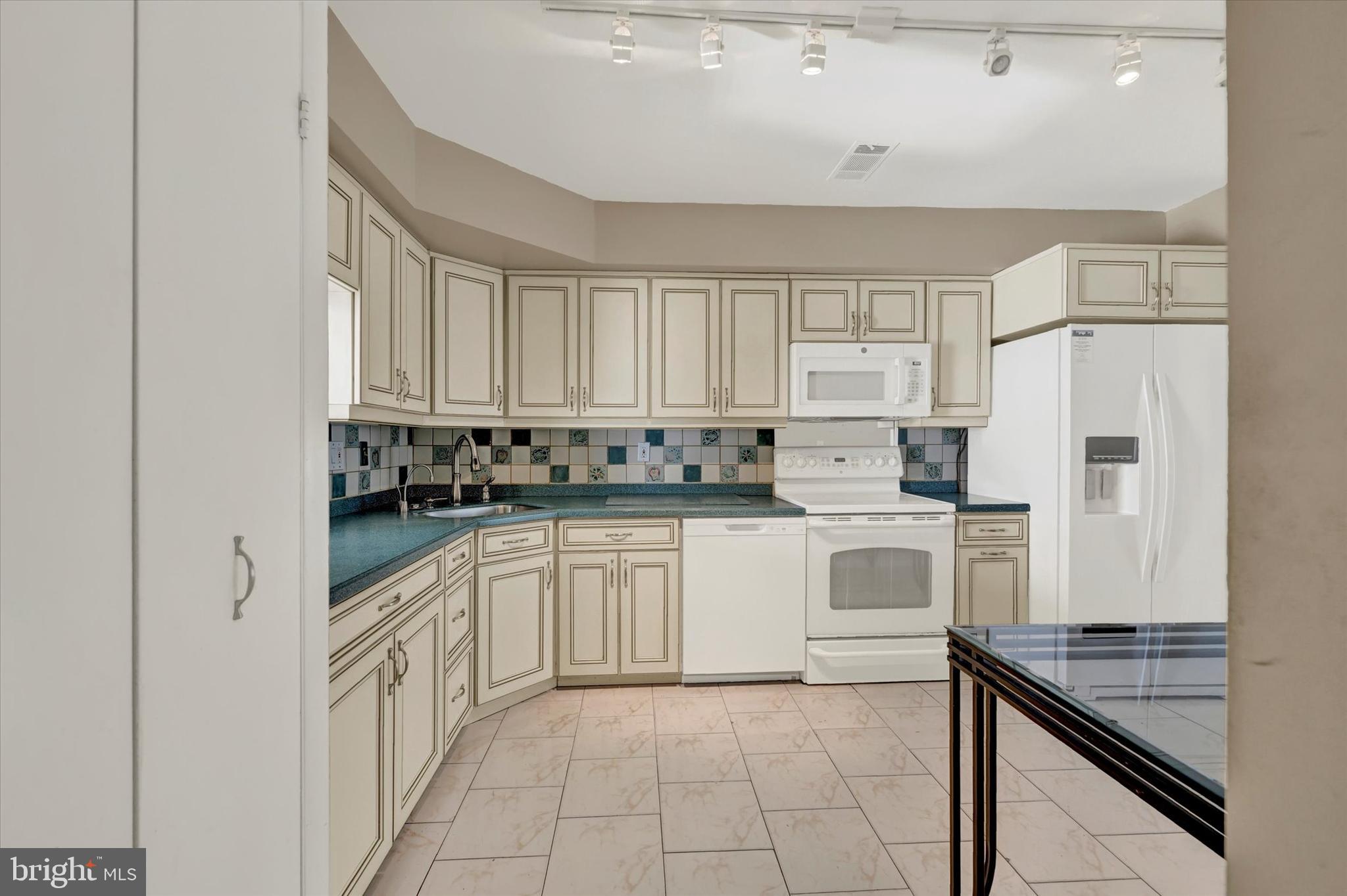 25 Tanner Court, Unit H Baltimore, MD 21208 - Photo 8 of 29 a kitchen with white cabinets and white appliances