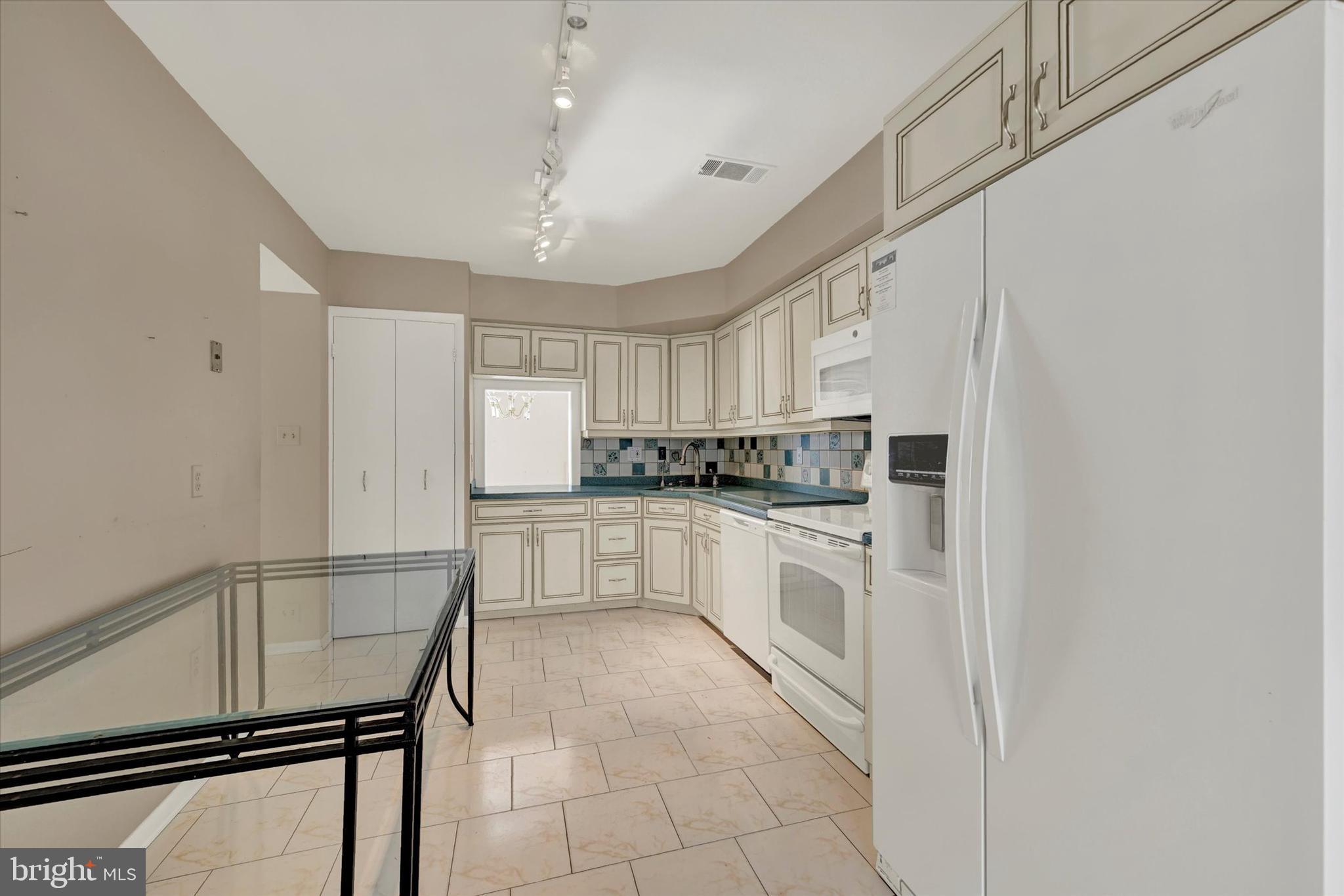 25 Tanner Court, Unit H Baltimore, MD 21208 - Photo 10 of 29 a kitchen with white cabinets and white appliances