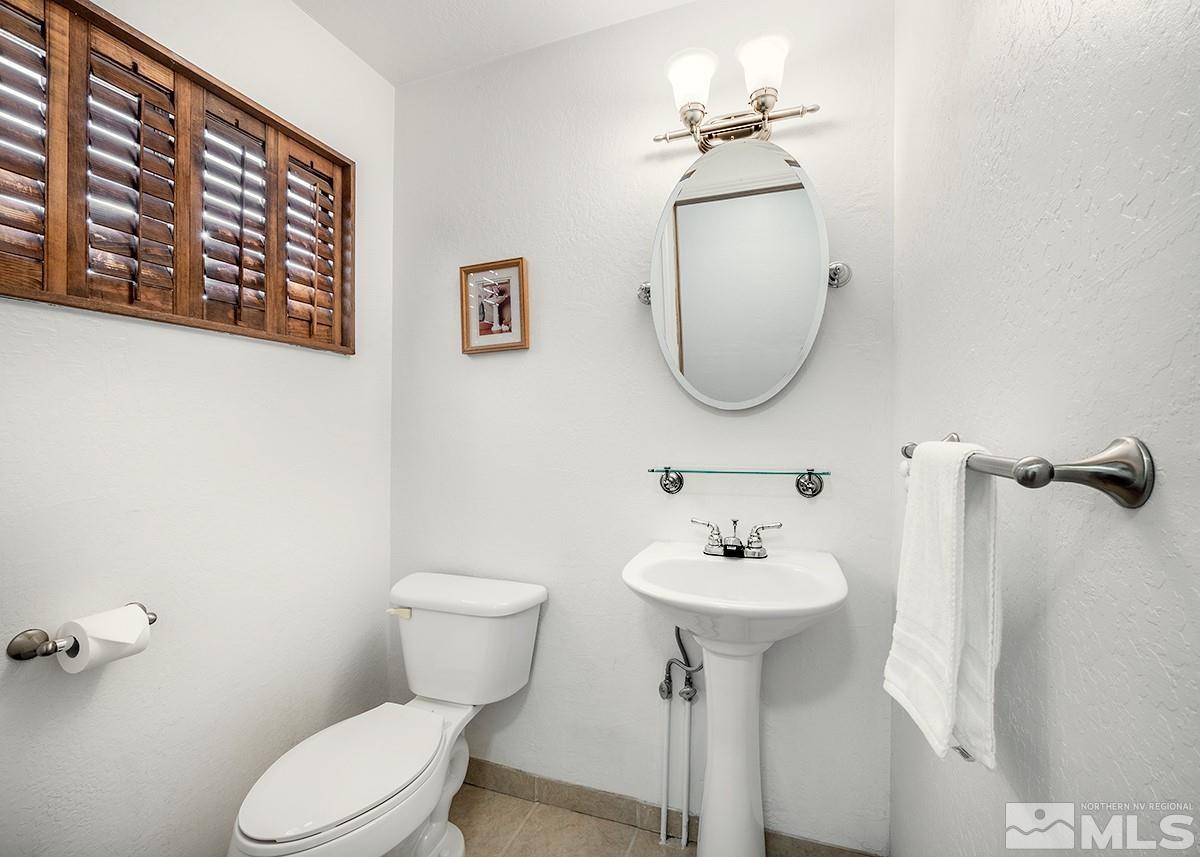 679 James Lane Reno, NV 89503 - Photo 19 of 25 a bathroom with a toilet a sink and mirror