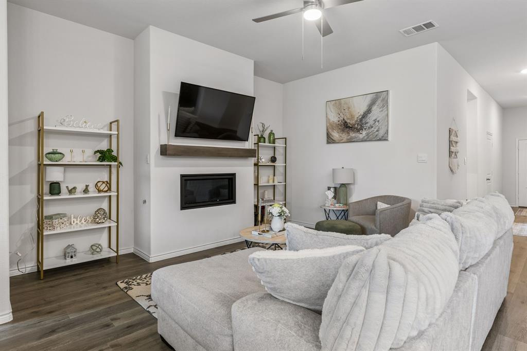 Living area featuring wood-finish flooring, a contemporary ceiling fan, and recessed lighting