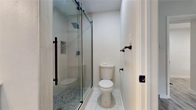a bathroom with a toilet and a shower