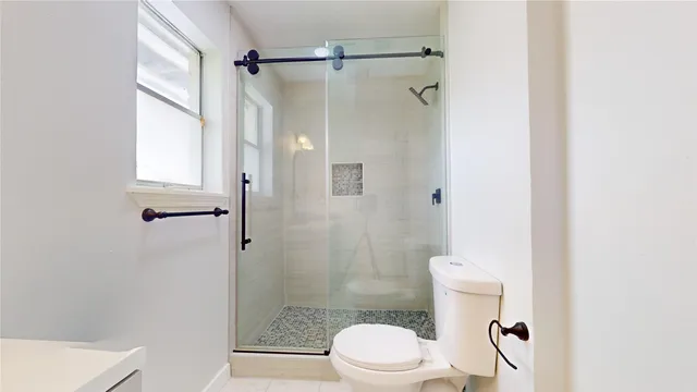 a white toilet sitting next to a shower
