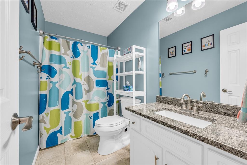 1670 Alcovy River Drive Dacula, GA 30019 - Photo 20 of 43 a bathroom with a granite countertop toilet sink and mirror