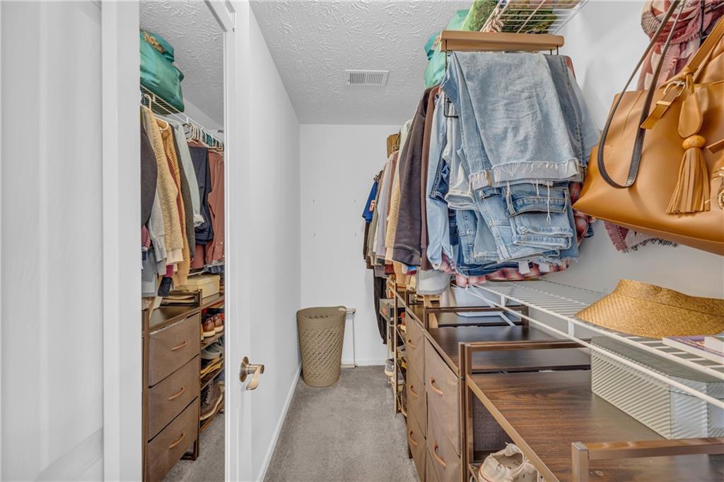 1670 Alcovy River Drive Dacula, GA 30019 - Photo 23 of 43 a view of walk in closet with clothes and shoes