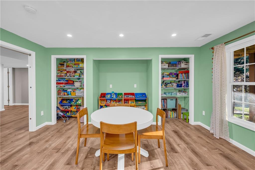 1670 Alcovy River Drive Dacula, GA 30019 - Photo 28 of 43 a dining room with a wooden floor and a book shelf