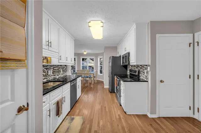 a kitchen with granite countertop cabinets and white appliances