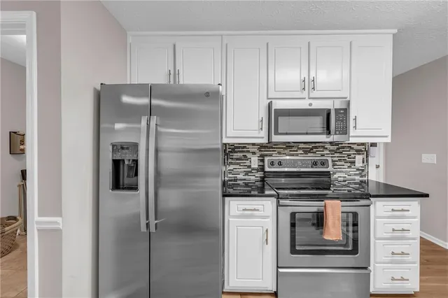 a kitchen with granite countertop a stove and a wooden floors