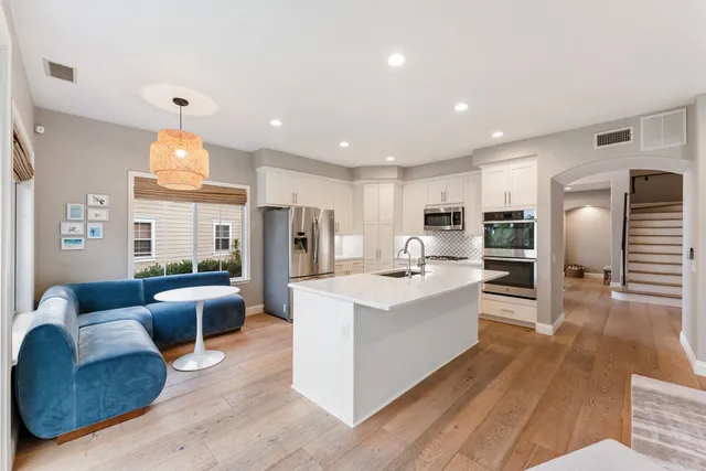 a view of a dining room with furniture a chandelier and wooden floor