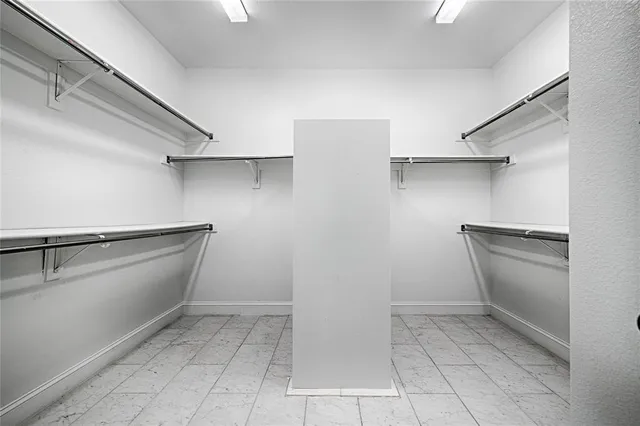 a view of walk in closet with empty racks